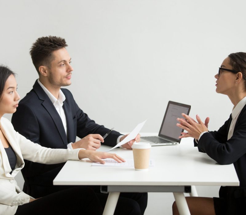 Female job applicant interviewed by two HR managers reading her resume, employee talking about experience, sharing thoughts during recruitment process. Concept of hiring, employment, cooperation
